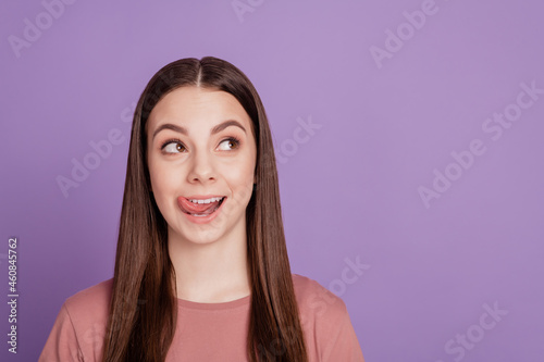Photo of pretty lady lick tongue teeth lips look empty space isolated on purple background