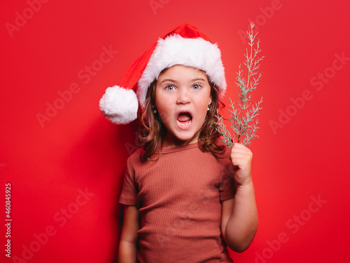 Funny kid in Xmas costume in studio with opened mouth photo