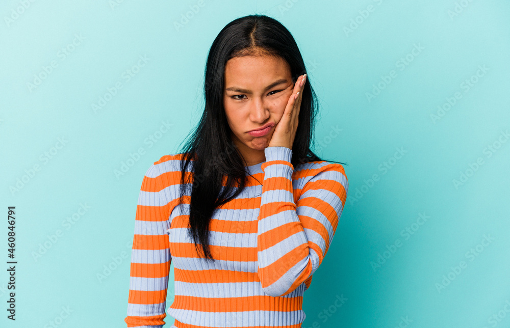 Young Venezuelan woman isolated on blue background who feels sad and pensive, looking at copy space. Young Venezuelan woman isolated on blue background who feels sad and pensive, looking at copy space.