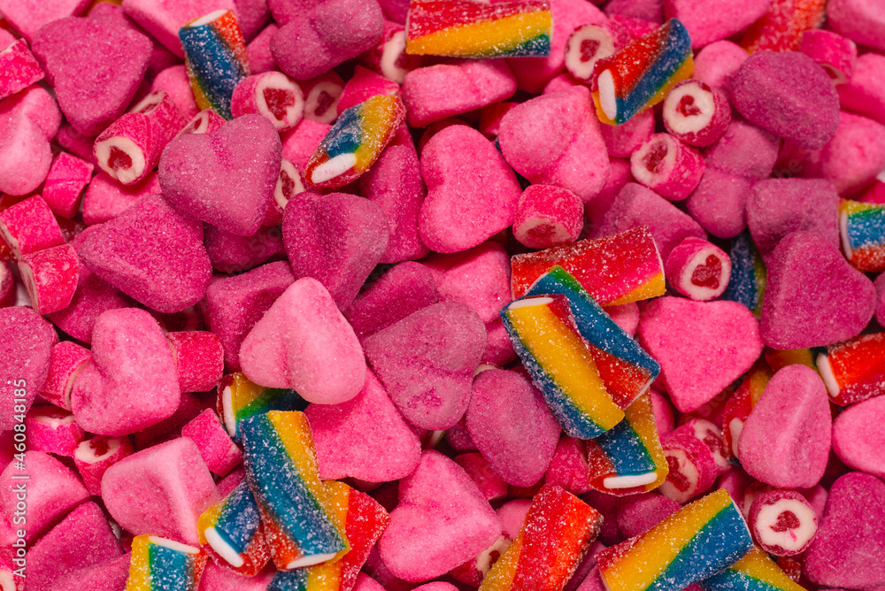 Assorted tasty gummy candies. Pink jelly sweets background.