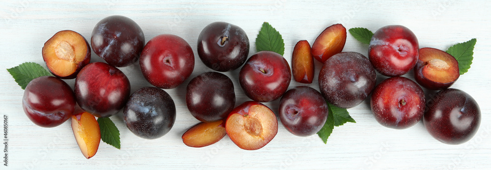 Flat lay composition with plums on white wooden background Flat lay composition with plums on white wooden background