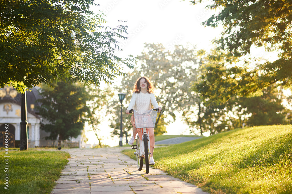 A young girl riding a bike in sunlight in the park A young girl riding a bike in sunlight in the park