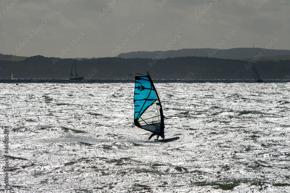 Naklejka premium Wind surfer out on The Solent Hampshire England with the Isle of Wight in the background on a grey Autumn day
