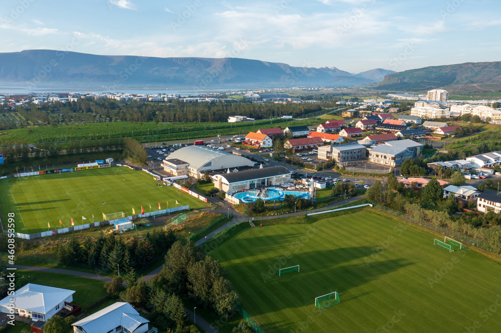 Aerial view of green football fields located near suburban houses Aerial view of green football fields located near suburban houses