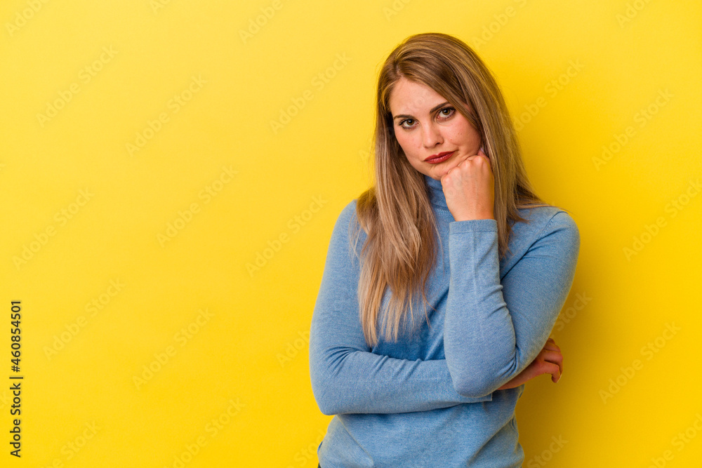Young russian woman isolated on yellow background who feels sad and pensive, looking at copy space. Young russian woman isolated on yellow background who feels sad and pensive, looking at copy space.
