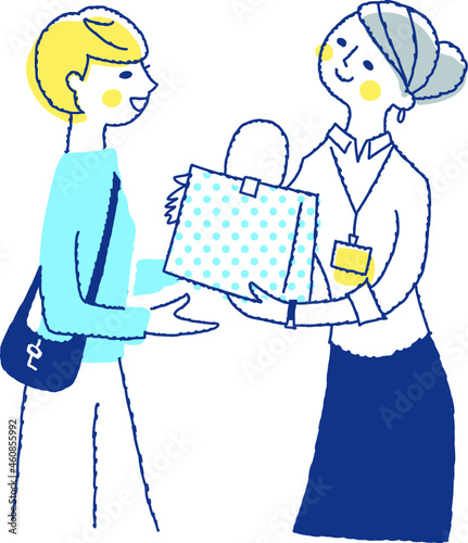 商品を手渡す女性店員と受け取る客の女性