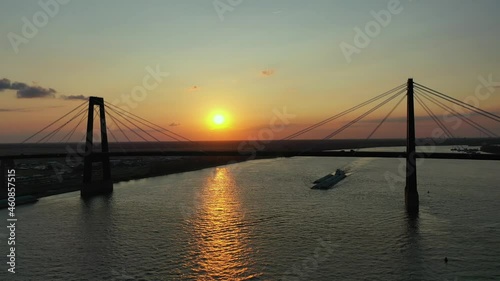 Hale Boggs Memorial Bridge and Push boat and barge at sunset photo