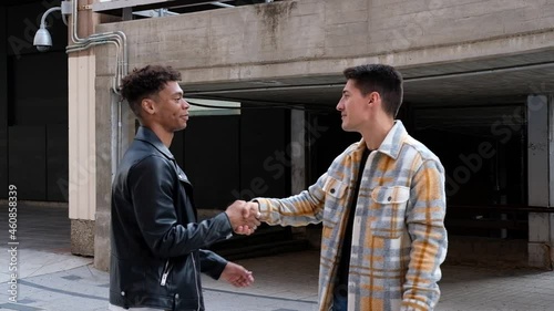 two young male friends saying goodbye to each other in the street