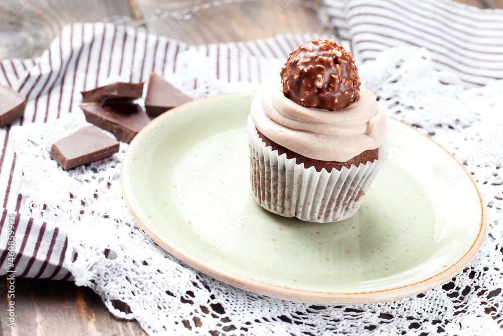 Chocolate muffin in a plate on a wooden table. Chocolate muffin in a plate on a wooden table.