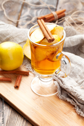 Apple and cinnamon drink. On a wooden table.