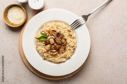 Tableau sur toile A plate of risotto with mix of mushroom and taleggio cheese on stone beige table