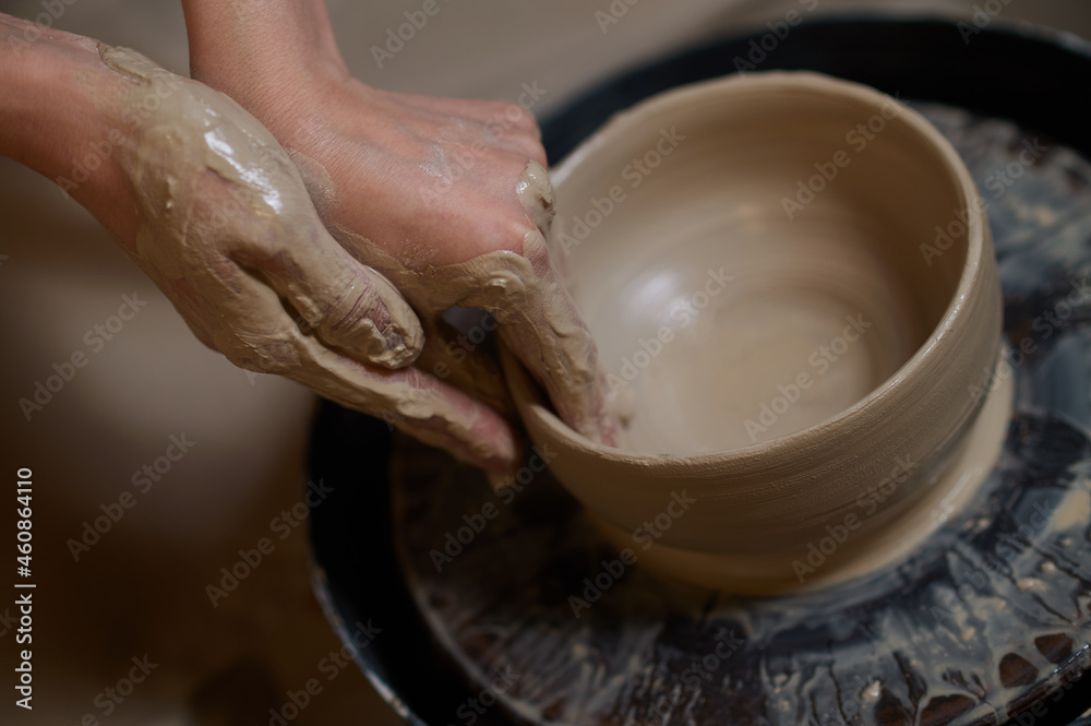 Close up of human hands making a bowl on a pottery wheel - obrazy, fototapety, plakaty 