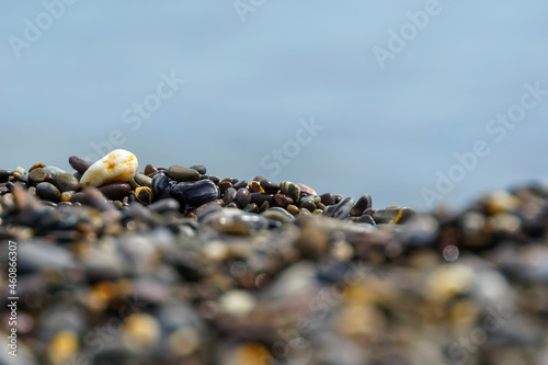 pebbles on the shore with a blurred foreground