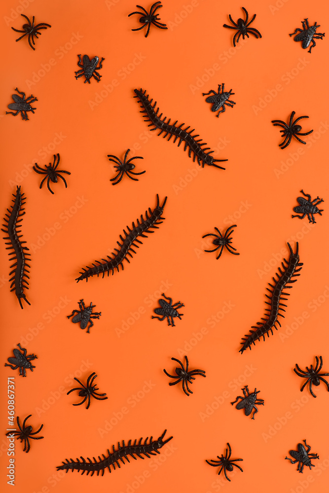 scary halloween pattern of various insects in black on a bright orange background backdrop. decor for the holiday in the form of creepy spiders. simple flat lay, top view scary halloween pattern of various insects in black on a bright orange background backdrop. decor for the holiday in the form of creepy spiders. simple flat lay, top view