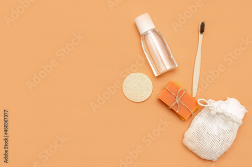 Bathroom accessories with zero waste, natural bristle brush, sponge, bars of solid soap, cosmetic bottle on a beige background