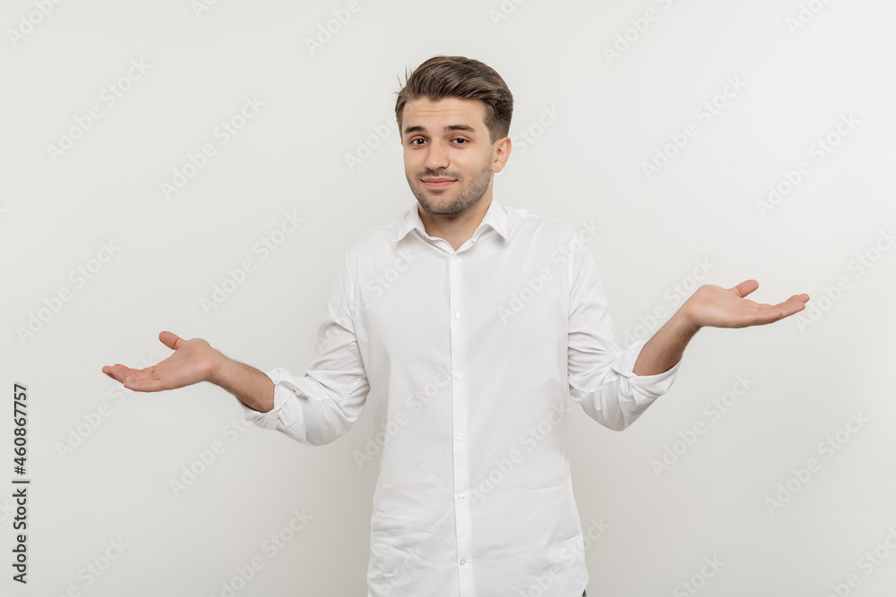 Portrait of a confused young bearded man casually dressed standing isolated over white, shrugging shoulders. I have no idea i am not sure I don`t know concept. Portrait of a confused young bearded man casually dressed standing isolated over white, shrugging shoulders. I have no idea i am not sure I don`t know concept.