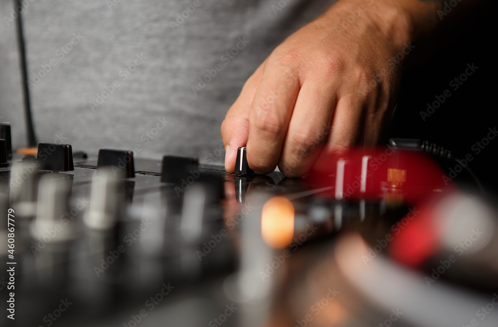 Hip hop dj hand on cross fader knob. Professional disc jockey sound mixer device on stage Hip hop dj hand on cross fader knob. Professional disc jockey sound mixer device on stage