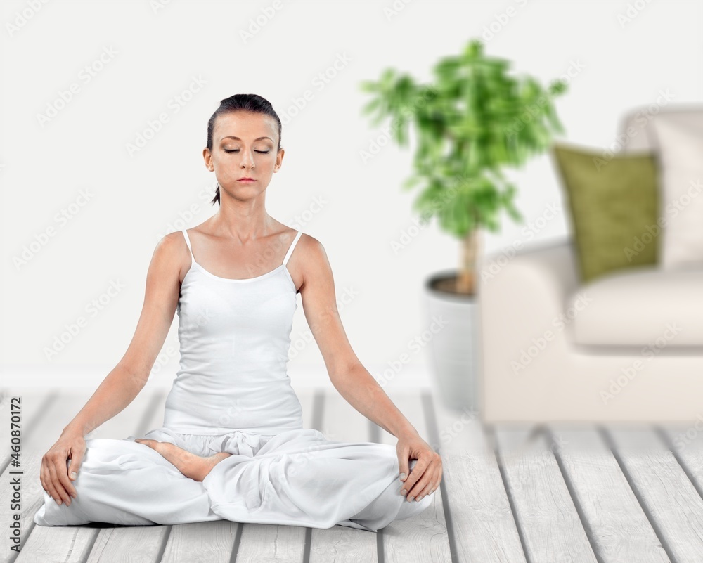 The girl does yoga, woman at home practices asanas. Hands on chest, mudra. The girl does yoga, woman at home practices asanas. Hands on chest, mudra.
