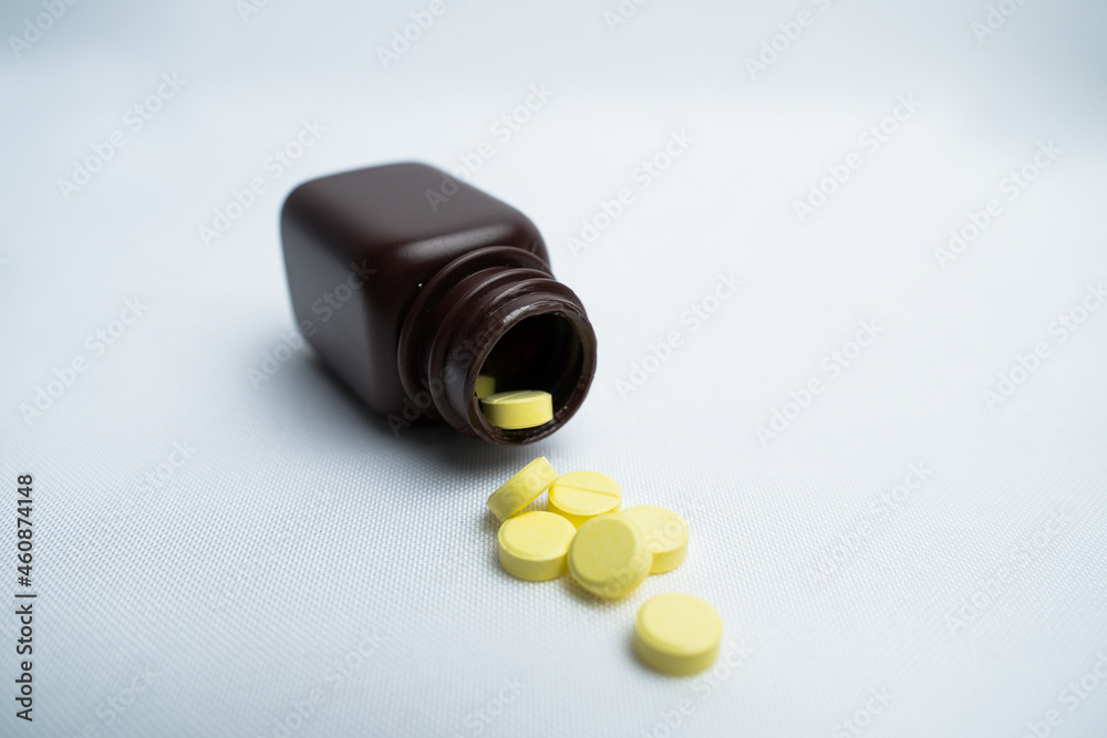 Brown pill bottle spilling pills on a white background Brown pill bottle spilling pills on a white background