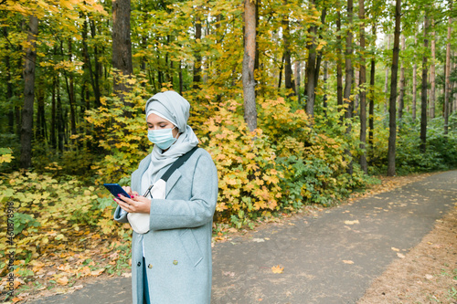 Muslim woman with hijab is wearing face mask outdoors. Coronavirus, health care and pandemic concept. Copy space © satura_