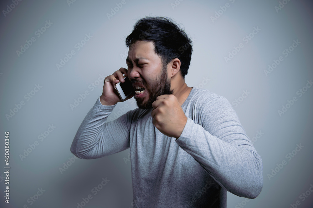 Asian handsome man angry on white background,Portrait of young Stress male concept,Bad mood after talking on the phone Asian handsome man angry on white background,Portrait of young Stress male concept,Bad mood after talking on the phone