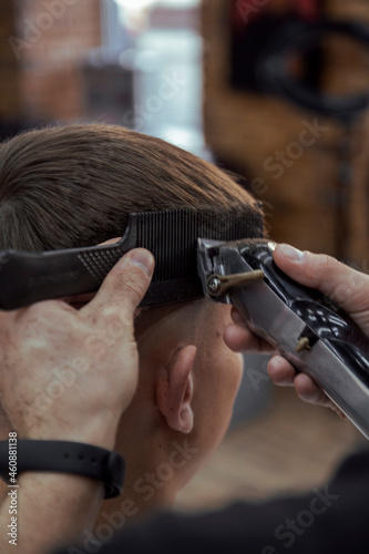 barber making a hairstyle with hairclipper photo