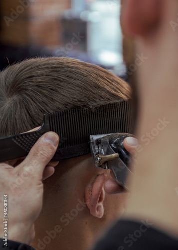 hairdresser cutting hair with hairclipper