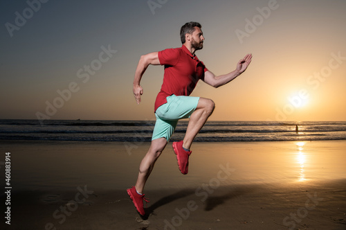 athletic man runner running on sunset summer beach, athlete