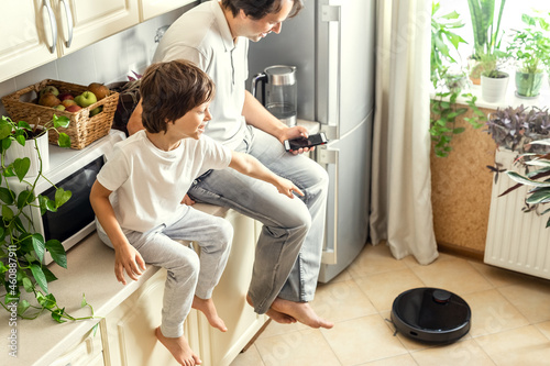 Father and Son Using Robotic Vacuum Cleaner