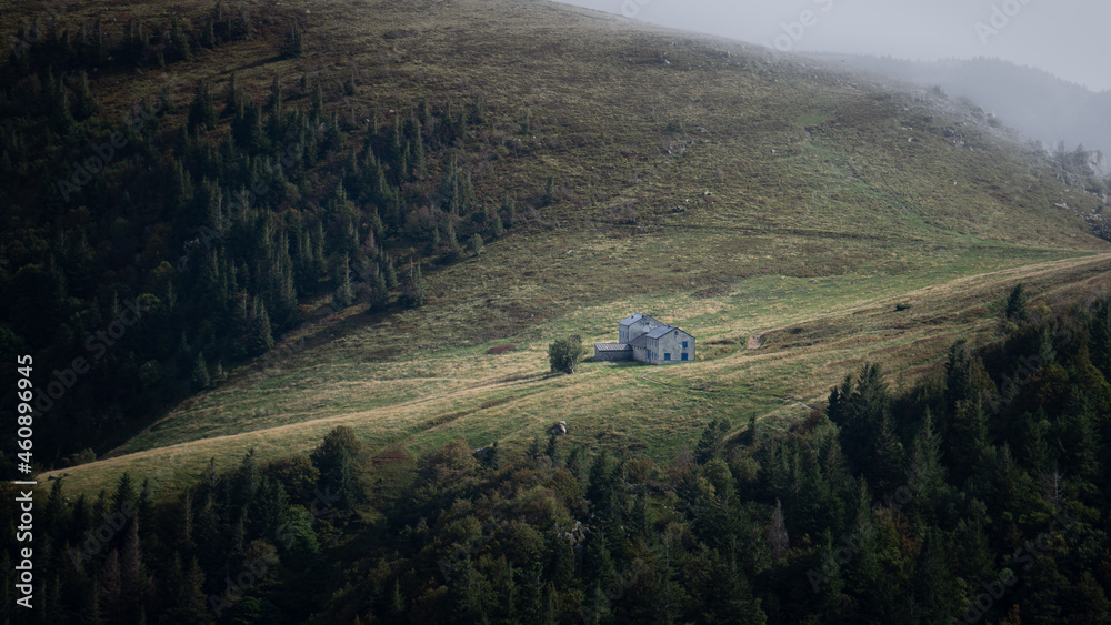 Single mountain cabin in the morning on a foggy day high up in the mountain.