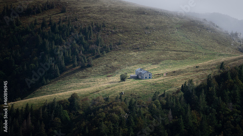 Single mountain cabin in the morning on a foggy day high up in the mountain.