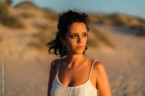 Chica delgada morena con aparatos en la playa al atardecer