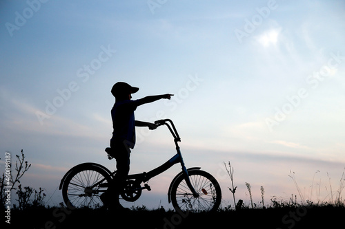 silhouette of a boy on a bicycle in nature