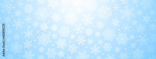 Christmas background of big and small complex snowflakes in light blue colors