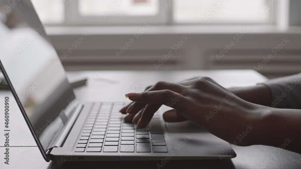 Close-up of unrecognizable female hands of programmer typing on laptop keyboard