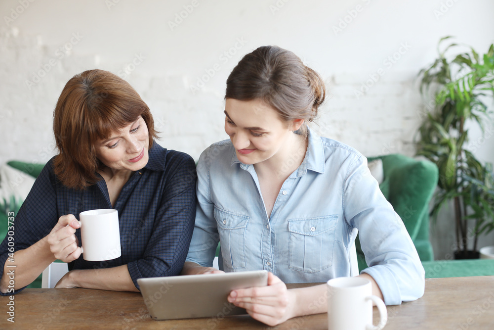 mother and adult daughter using tablet computer at home mother and adult daughter using tablet computer at home