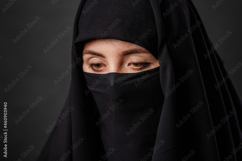 Close up portrait of young, adult woman in black burqa with hidden face, isolated on black background. Close up portrait of young, adult woman in black burqa with hidden face, isolated on black background.