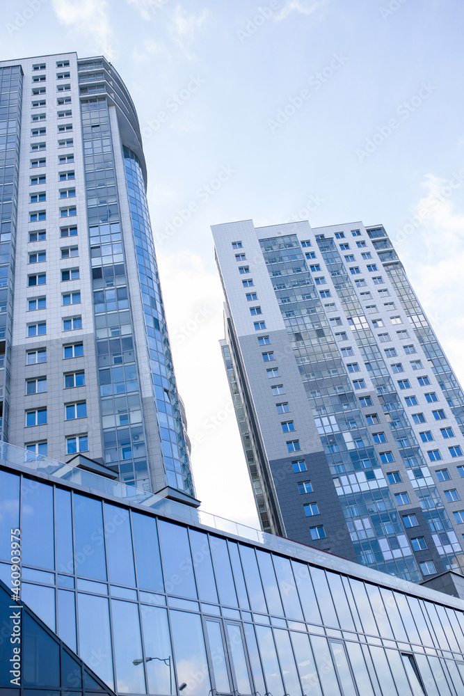 Tall buildings in the city against the blue sky, urban high-rise buildings.
