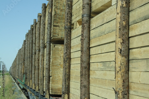 A freight train loaded with processed planks, logs, trunks. Environment, nature and deforestation forest - cutting down trees. The concept of a global environmental problem.