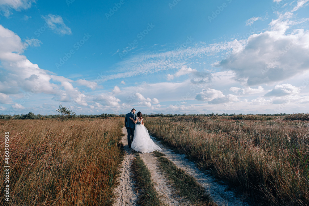 Obraz premium bride and groom newlyweds at the sea. lovely young couple, woman in wedding dress and man in suit by the sea or ocean are spending their honeymoon