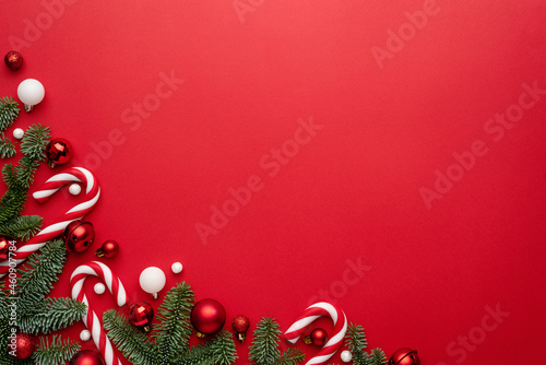 Red background with fir, candy cane and Christmas bauble for Christmas design