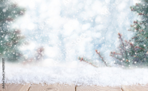 wooden tabletop with snow in the winter forest	