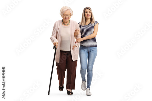 Full length portrait of a young woman helping an elderly woman and walking towards camera