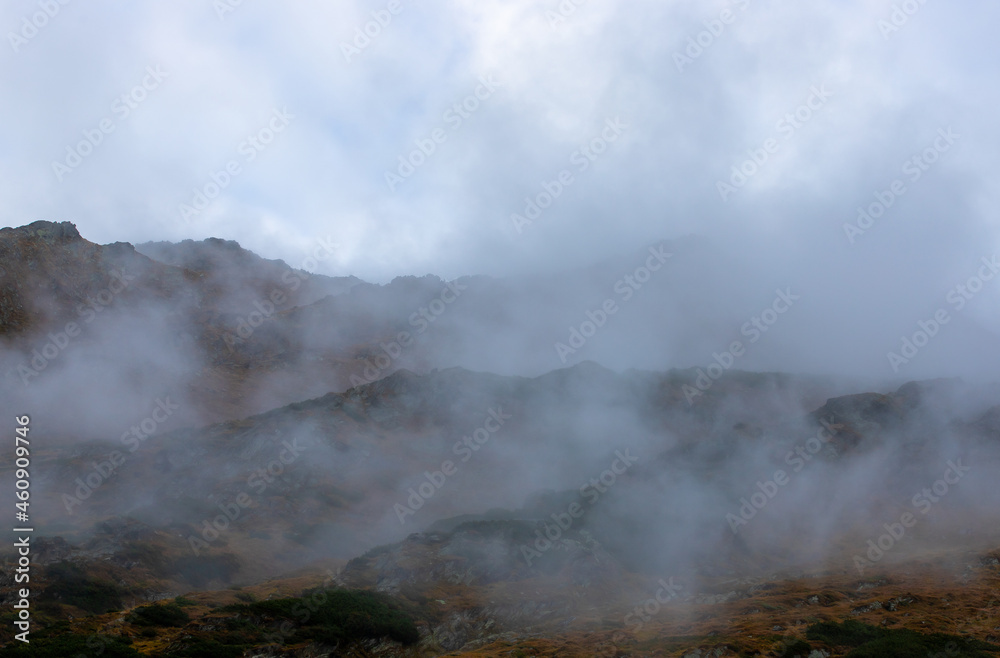 a beautiful landscape with fog on the mountain slope