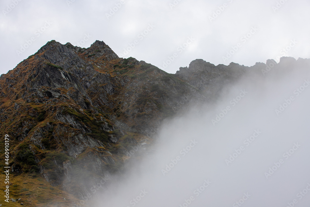 a beautiful landscape with fog on the mountain slope