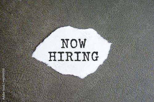 now hiring sign on the torn paper on the gray background