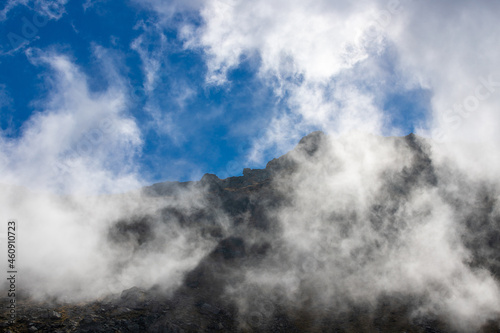 landscape with fluffy clouds on the mountain tops