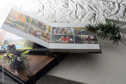 Luxury wooden photo book, wooden box with summer photos printed and flash card on linen natural background. Family memories photobook. Save your summer vacation memories. Photo album with wooden cover photo