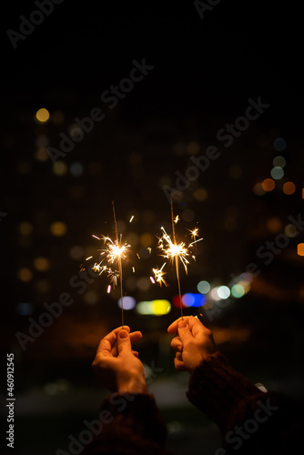 Close-up of a sparkler in the hands of a happy girl. Celebrating Christmas and New Years. Holiday