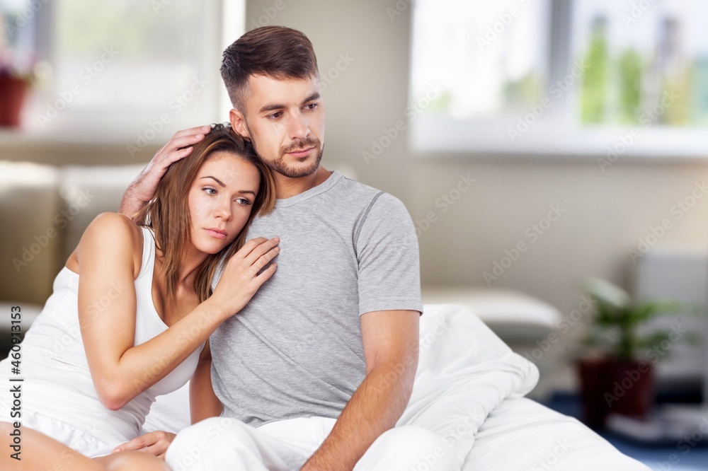 Depressed young man sitting in bed cannot sleep from insomnia Depressed young man sitting in bed cannot sleep from insomnia